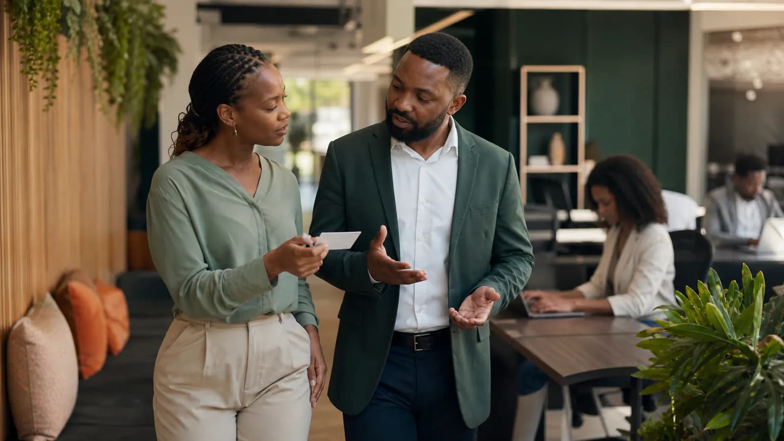 New employee and manager discussing a blank promise card inside the workplace